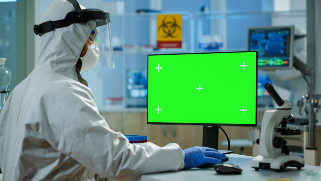 Corvalent man researcher coverall looking chroma key computer modern equipped lab team microbiologists doing vaccine research writing device with green screen isolated mockup display 1